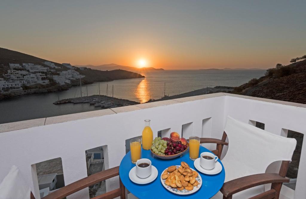 阿斯提帕莱亚镇Yalos rooms的阳台上的一张桌子,上面放着一碗水果,还可欣赏到日落美景