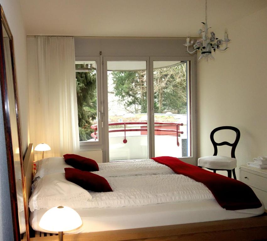 巴塞尔Exclusive Central Apartment的一间卧室配有一张带红色枕头的床和一扇窗户