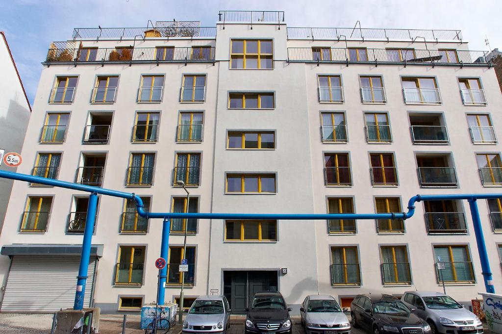柏林拉加约斯皮公寓 - 斯皮特尔马克特米特 的一座白色的建筑,前面有汽车停放