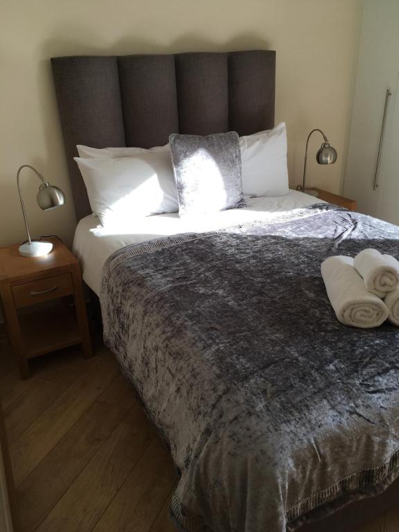吉尔福德Blue Sky Apartments@Guildford Town Centre的一间卧室配有一张大床和两条毛巾