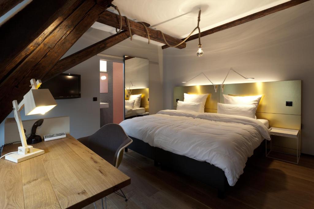 施韦比施哈尔施洛酒店的一间卧室配有一张大床和一张木桌