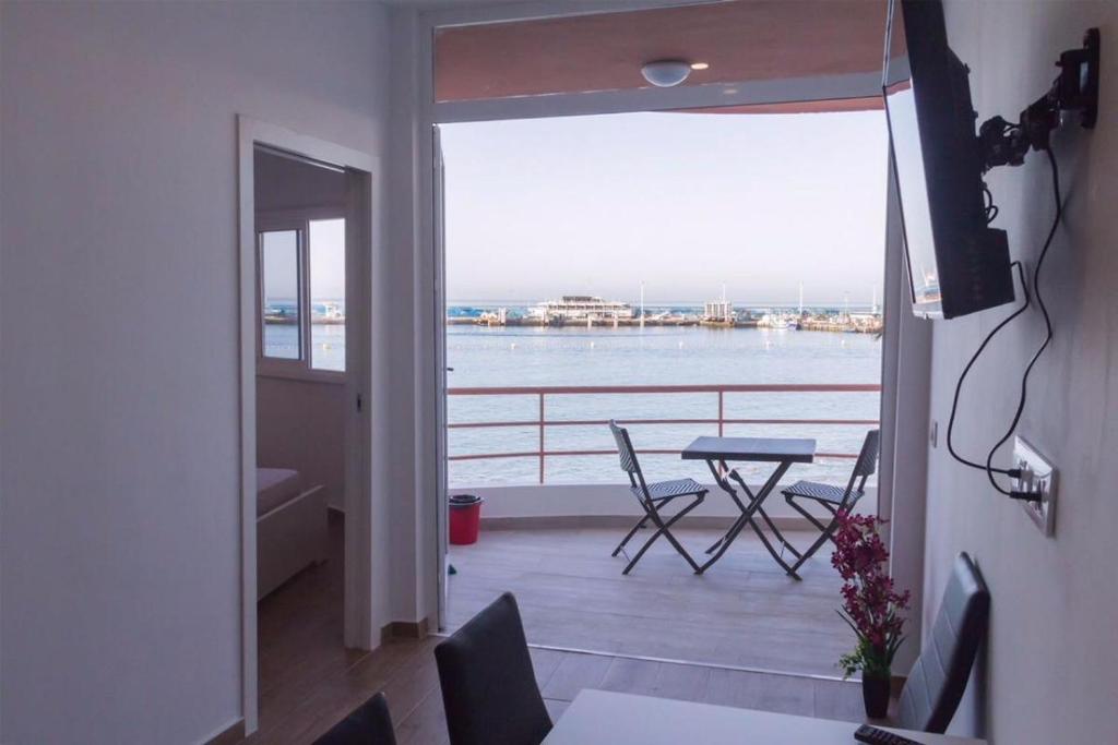 阿罗纳Paseo Marítimo, Los Cristianos Over the sea FREE WIFI的阳台配有桌椅,享有风景。