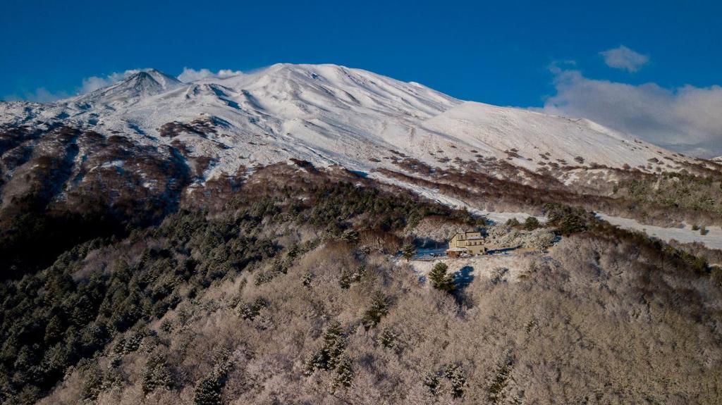 FornazzoRifugio Alpino Salvatore Citelli的山顶上有一所房子,被雪覆盖的山