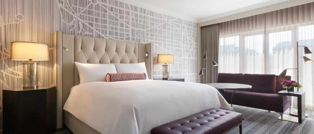 华盛顿Fairmont Washington DC Gold Experience的卧室配有一张白色大床和一把椅子
