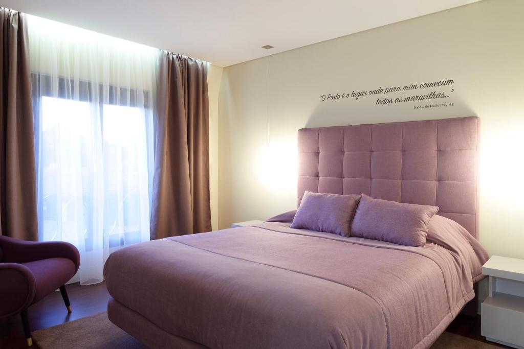 波尔图波尔图老城旅游公寓式酒店的一间卧室设有一张大床和一个窗户。