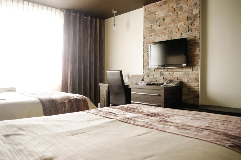Bécancour康姆普莱克斯55号酒店的酒店客房设有两张床和一台平面电视。