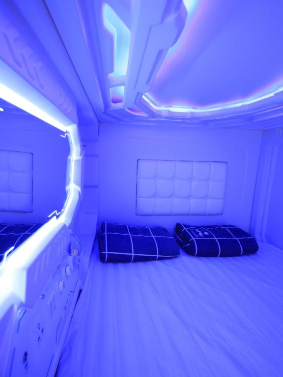 新加坡Spacepod@hive的紫色灯房内的两张床