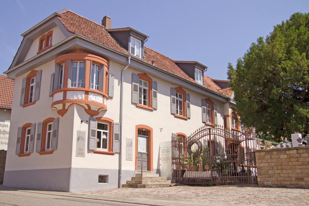 朗道因德普法尔茨德兰芝别墅酒店的白色的房子,设有橙色的窗户和栅栏