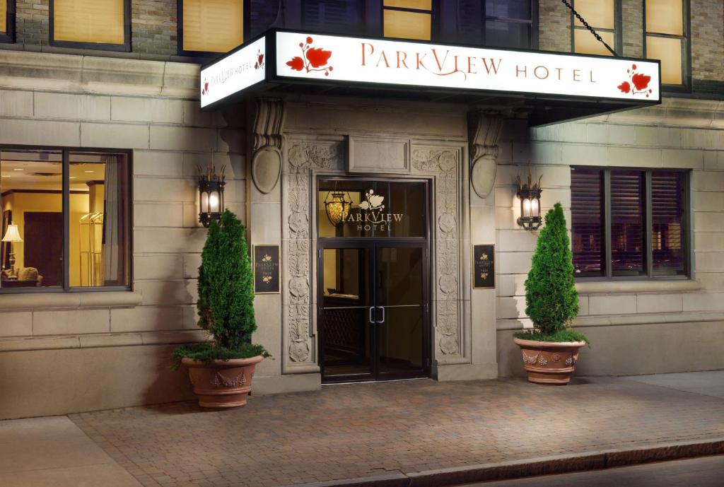 锡拉丘兹The Parkview Hotel的公园景酒店入口,前面有两株植物