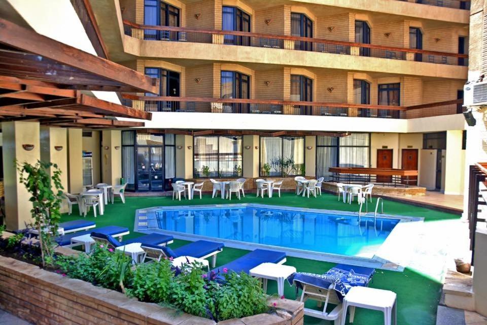卢克索加迪斯套房与公寓酒店的酒店设有带桌椅的游泳池