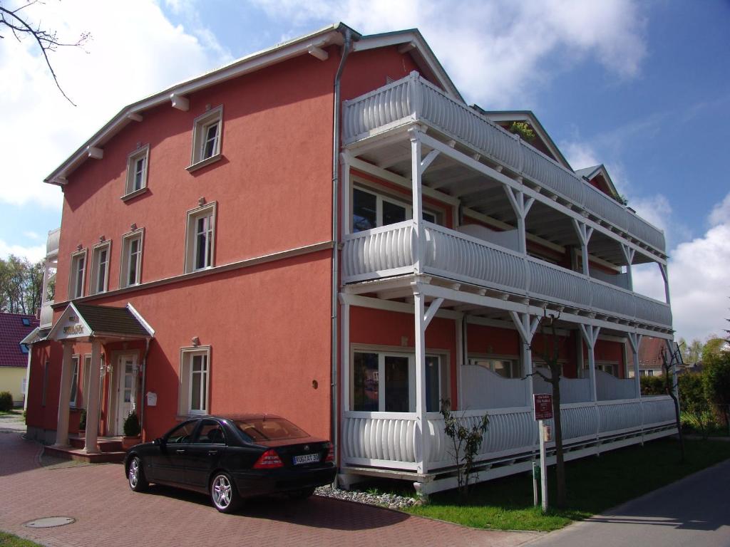 巴贝Apartments Villa Seeblick的一辆停在红色建筑前面的黑色汽车