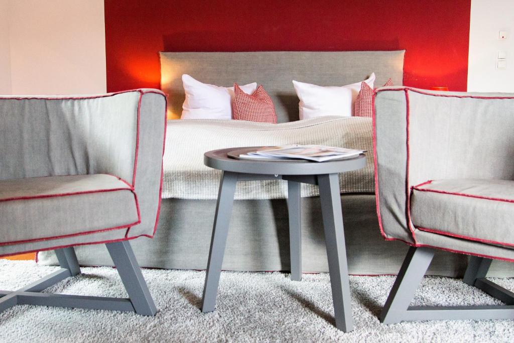 泰根塞路易特鲍尔德海滨酒店的一间卧室配有一张床、两把椅子和一张桌子