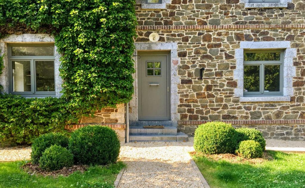 索海尔Cottage in Ardennes - La Maison aux Moineaux - Fays-Famenne的石头房子,设有门和两扇窗户