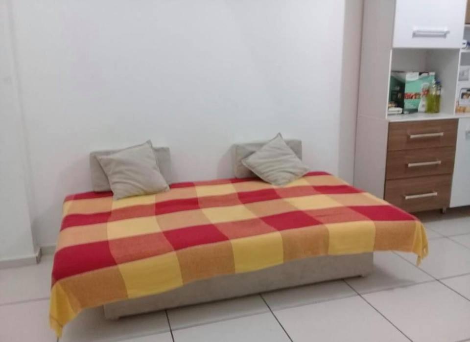路易斯科雷亚Flat Shopping Amarração N - 129的红色和黄色毯子的房间的一张床位
