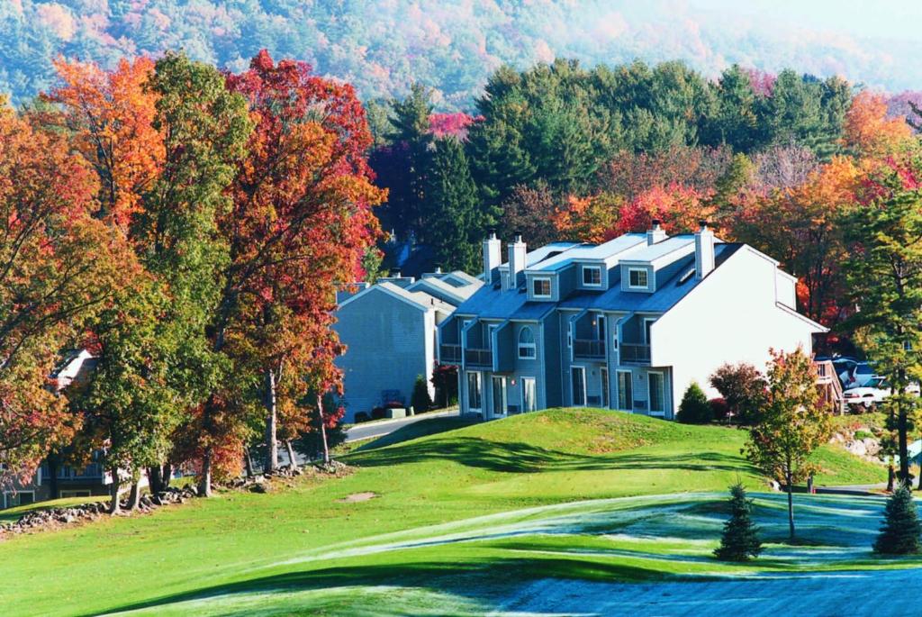 东斯特劳兹堡Pocono Mountain Villas by Exploria Resorts的一座大蓝色房子,位于一座种有树木的高尔夫球场上
