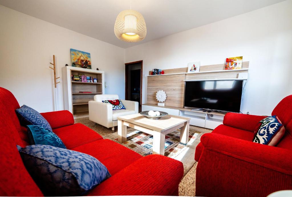 蒂哈拉费CASA LUJAN的客厅配有2张红色沙发和1台电视
