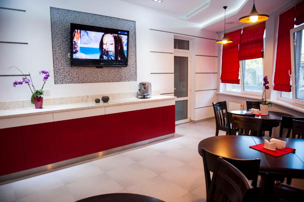 敖德萨艾阿卡迪亚精品公寓酒店的一间墙上配有电视的用餐室
