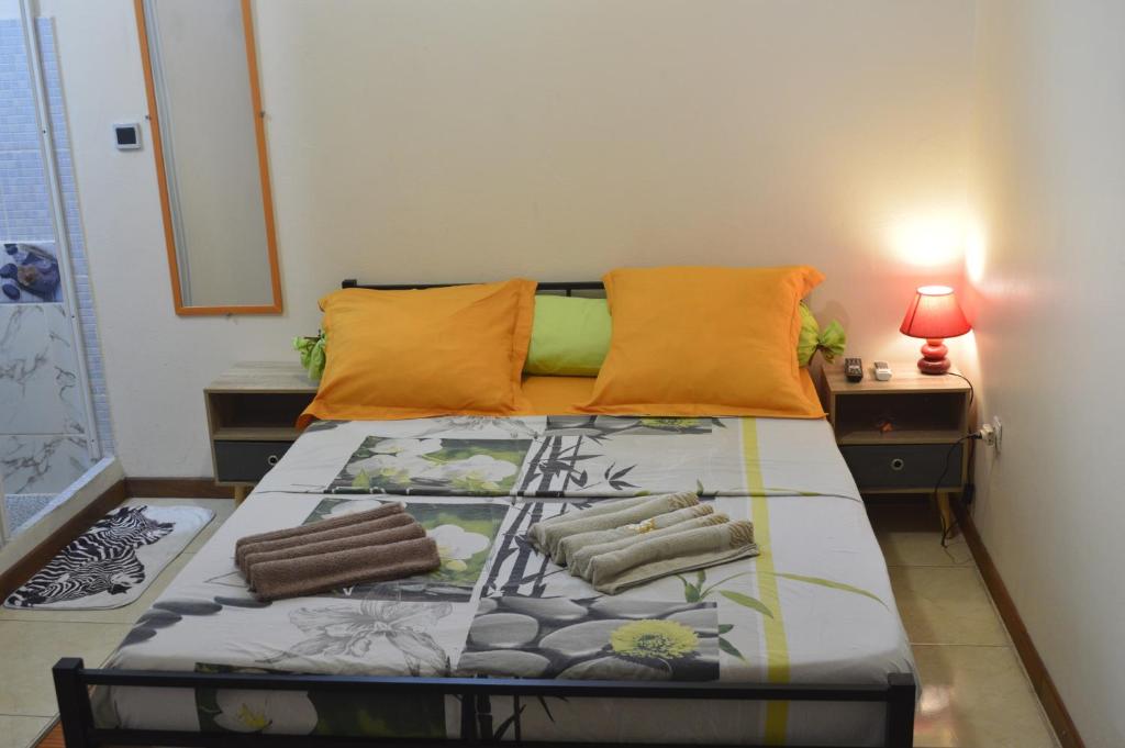 法兰西堡Résidence Plocus的一间卧室配有一张带橙色枕头的床