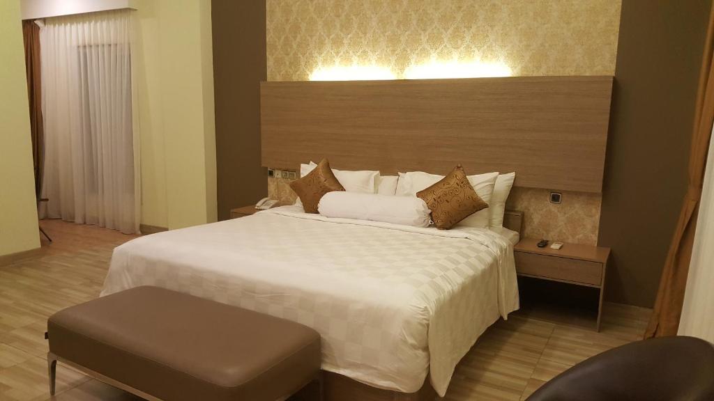 特尔纳特岛特尔纳特姆拉摩尔酒店的卧室配有一张白色大床和一把椅子