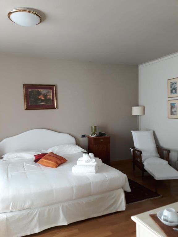 内伊韦Castelbourg的卧室配有白色的床和椅子