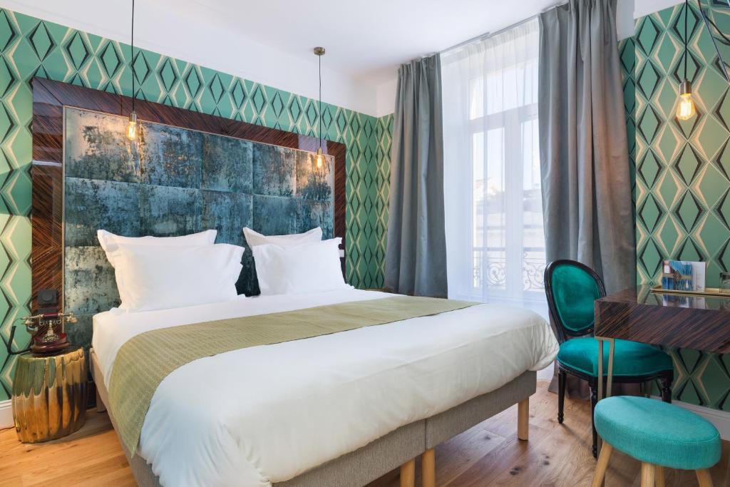 尼斯快乐文化杰伊酒店的一间卧室配有一张大床和一张书桌
