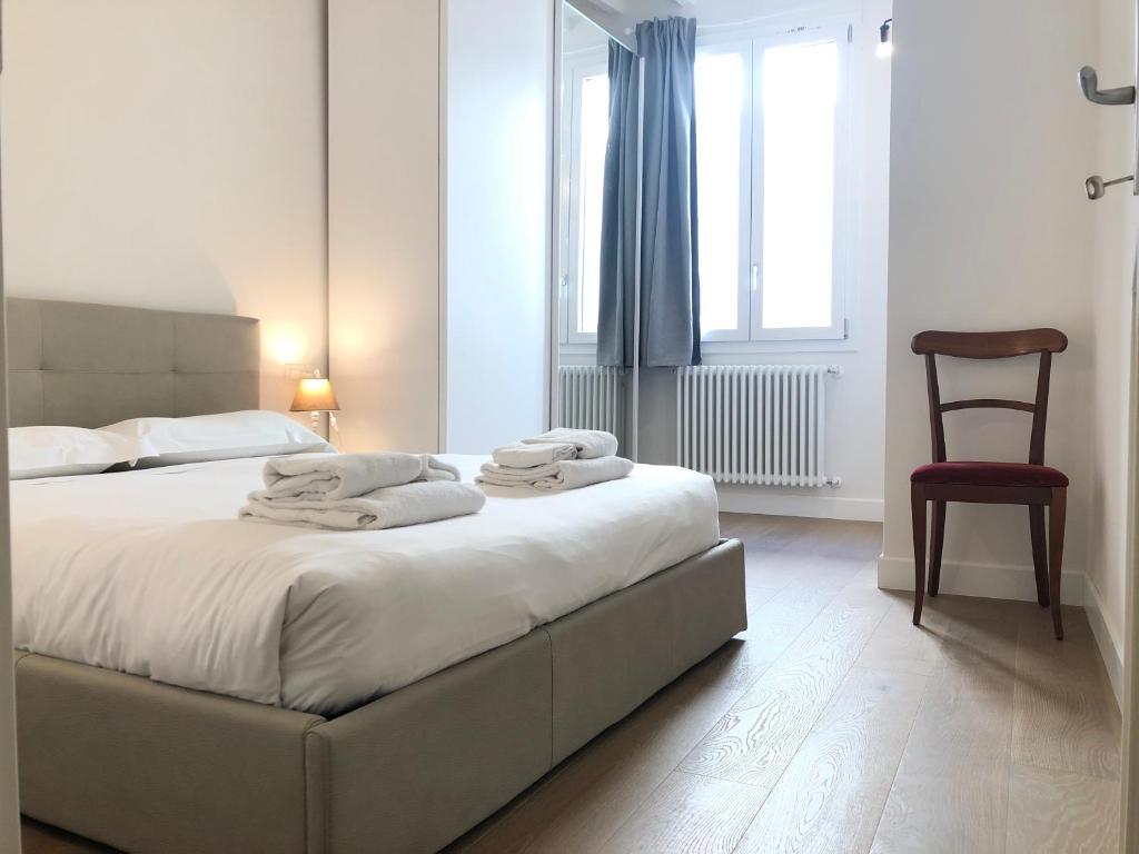 佛罗伦萨San Frediano Apartment的卧室配有床、椅子和窗户。