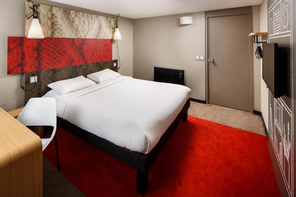 考文垂ibis Coventry South的卧室配有一张白色大床和红地毯