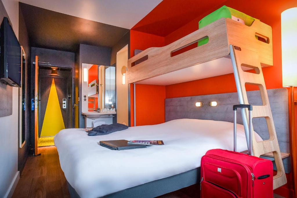 库唐斯库唐斯宜必思快捷酒店的一间卧室配有带梯子和手提箱的双层床