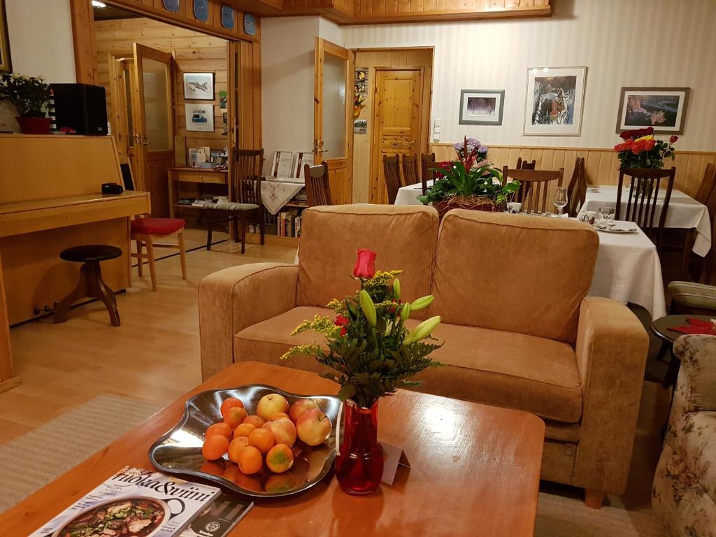 PetkeljärviHotelli Möhkön Rajakartano - Ilomantsi的客厅设有两张沙发和一张带水果的桌子