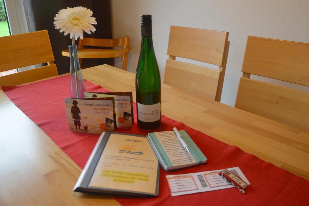 诺德代希Bungalow Tilla的一瓶葡萄酒和一张桌子上的书