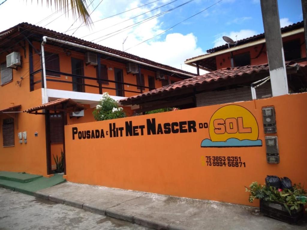 伊尔哈德博伊巴Pousada & Kitnet Nascer do Sol的一座橙色的建筑,旁边标有标志