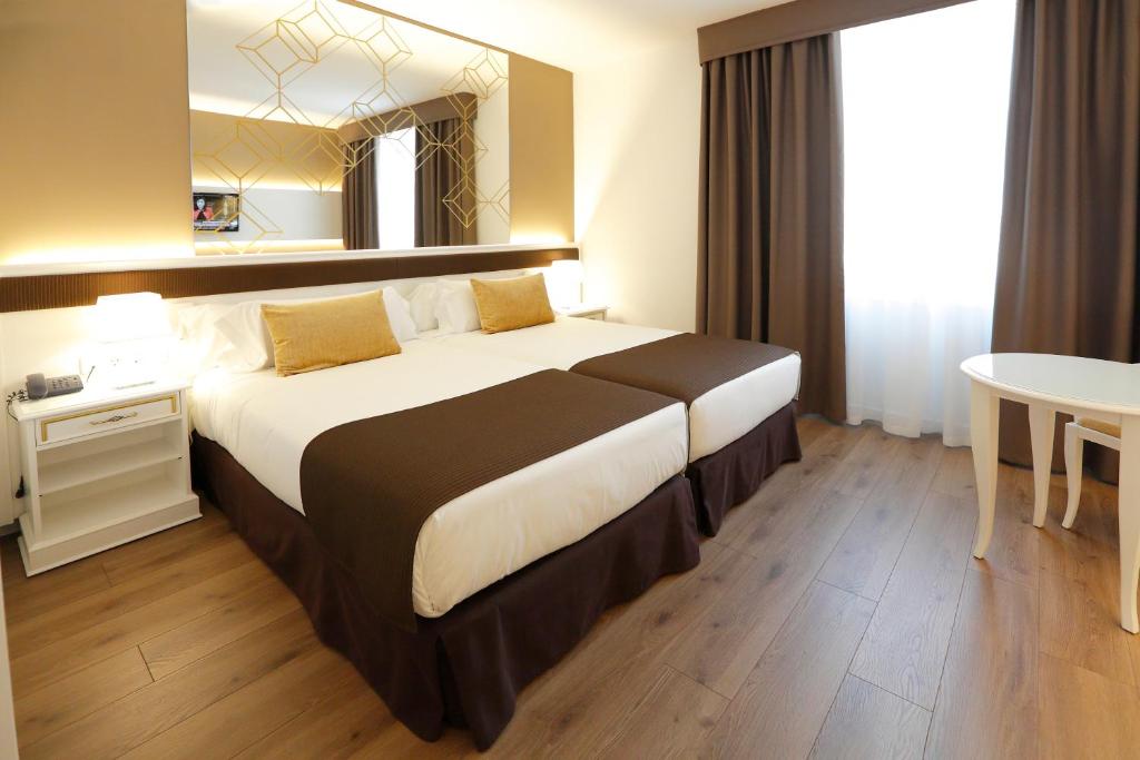 卡塔赫纳塞尔科蒂尔阿方索十三世酒店的酒店客房设有一张大床和一张桌子。