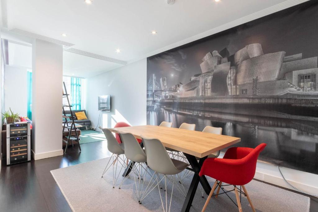 毕尔巴鄂BIG LUX BEACHCITY Ap 01的一间带木桌和红色椅子的用餐室