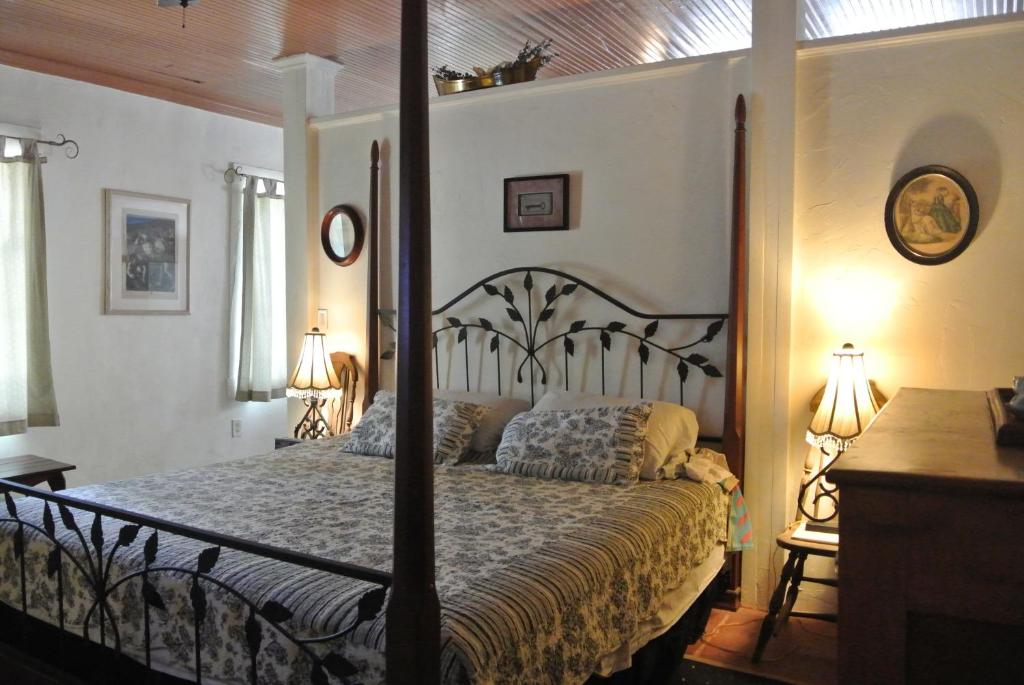 GilaInn at the L C Ranch的一间卧室配有四柱床和两盏灯。