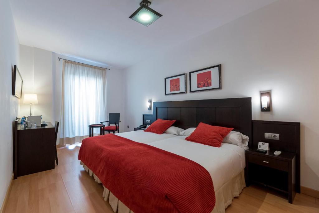 萨拉曼卡Itaca Salamanca by Soho Boutique的一间卧室配有一张带红色毯子的大床