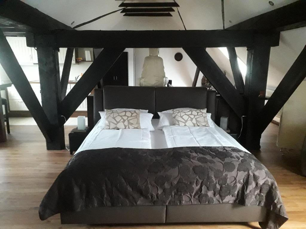 旺格兰兹姆滕克鲁格旅馆的一间卧室配有黑色床、白色床单和枕头