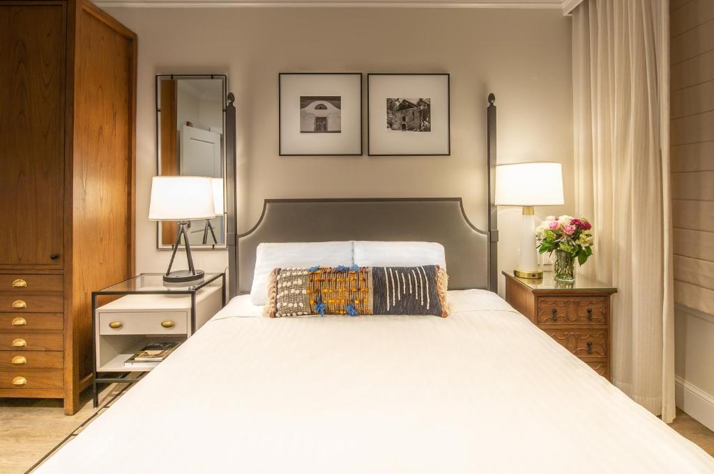 圣罗莎Hotel E的卧室配有一张白色大床和两盏灯。