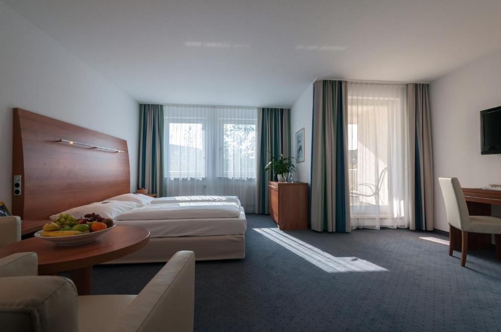 里登瑞奇弗杜纳艾尔贝酒店的酒店客房配有一张床铺和一张桌子。