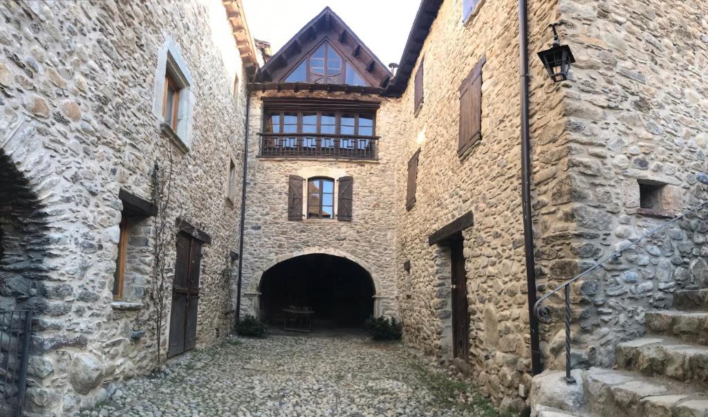 AncilesCasa Mingot SXVI Anciles Benasque的一条有隧道的古老石头建筑的小巷
