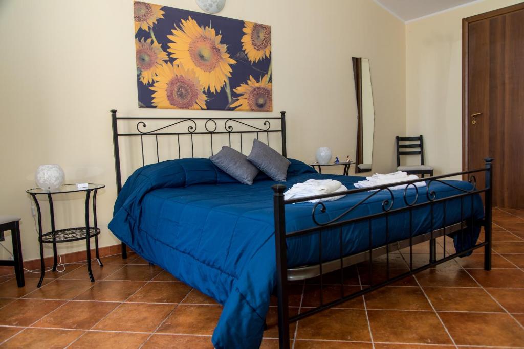 LineraGli Ulivi Dell'Etna的一间卧室配有一张带蓝色棉被的床