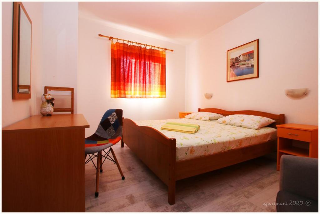 普利莫顿Apartments Zoro的一间卧室配有一张床、一张书桌和一个窗户。