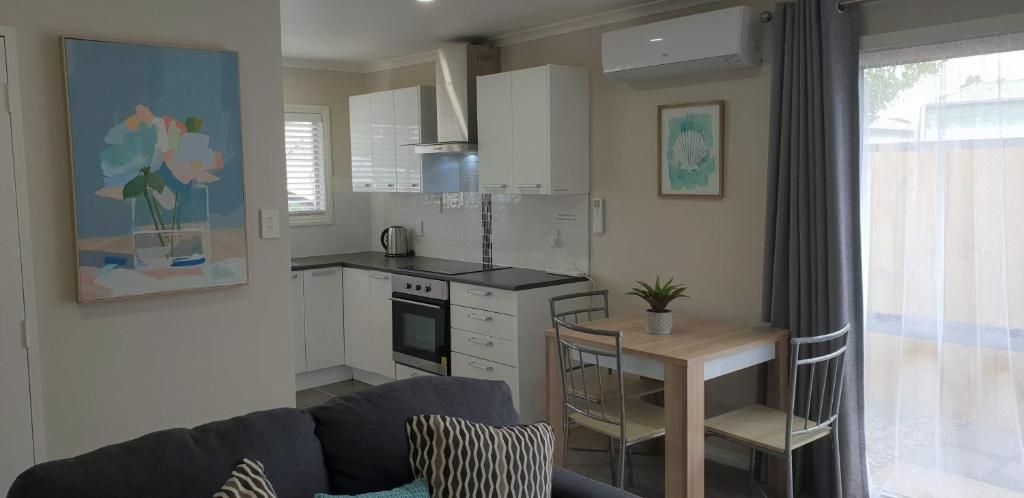 罗托鲁瓦Rose Apartments Unit 6 Central Rotorua-Accommodation & Spa的一间配有沙发和桌子的厨房