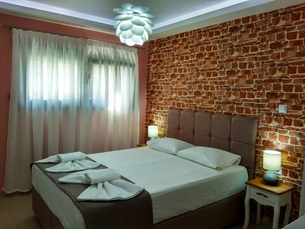 尼亚普拉莫斯Iros Apartment的一间卧室设有一张床和砖墙