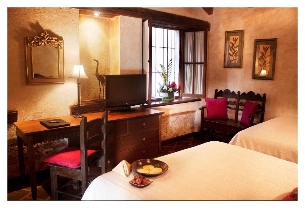 危地马拉安地瓜Meson de Maria的酒店客房配有书桌和电视。