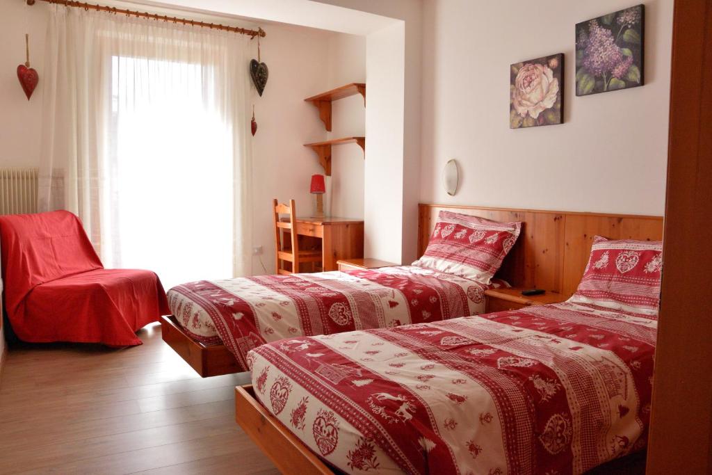 安达洛Appartamenti Osti Sansoni Mariarosa的一间卧室设有两张床和窗户。