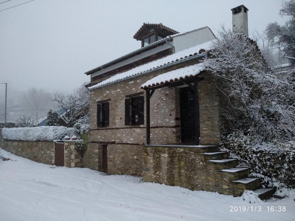 PalaiókastronTraditional Greek Cottage的雪中的小石头建筑