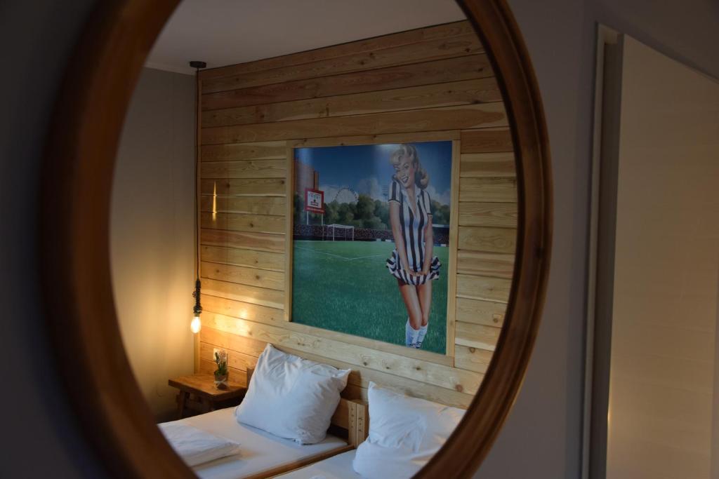 汉堡Hamburger Alm Hotel St. Pauli的镜子反射着一张墙上的照片的床