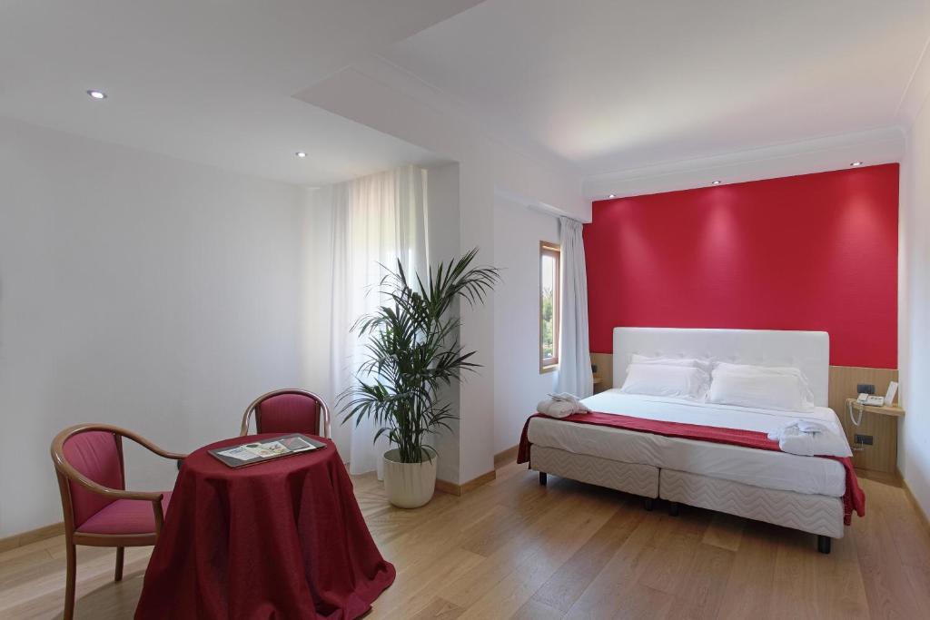 阿格里真托德拉瓦莱酒店的一间卧室设有一张床和红色的墙壁