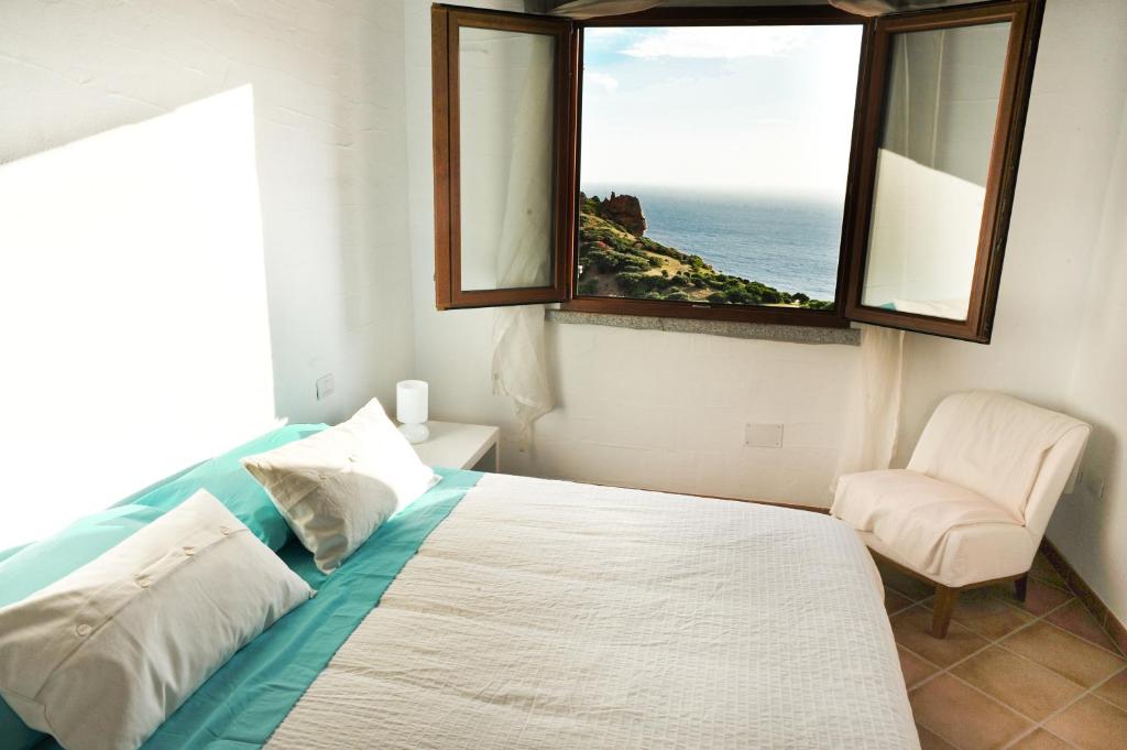 内比达Arromaniu的一间卧室配有一张带窗户和椅子的床