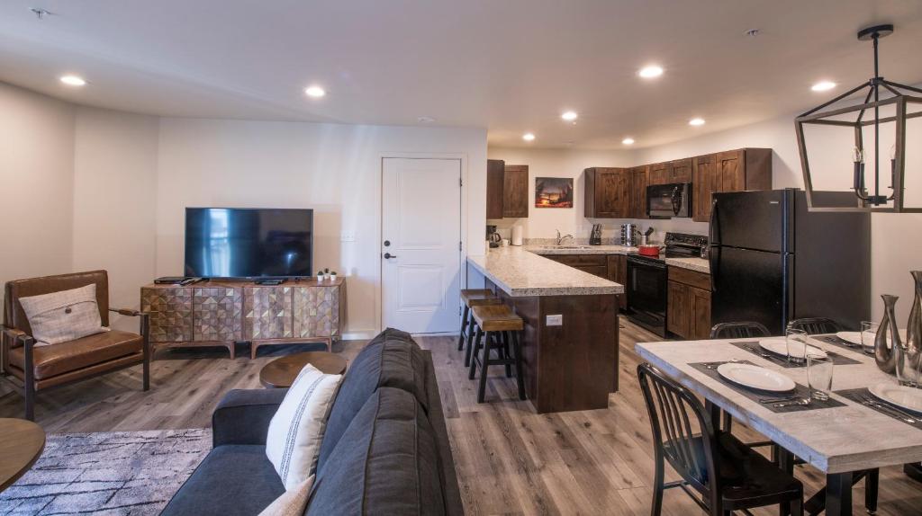 摩押Moab Redcliff Condos的客厅以及带沙发和桌子的厨房。